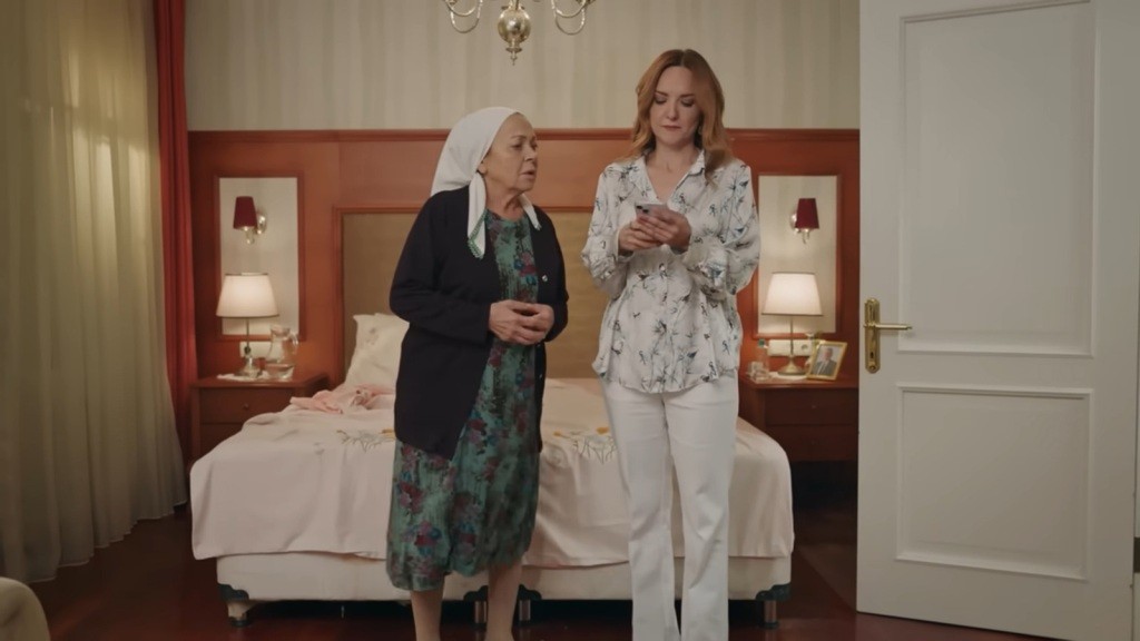 Songul pisze wiadomość do Zeynep. Zumrut staje na palcach, zerkając na jej telefon.