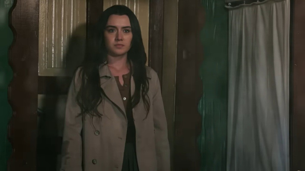 Zeynep stoi przed gankiem. Nocne powietrze przecinają krople deszczu.