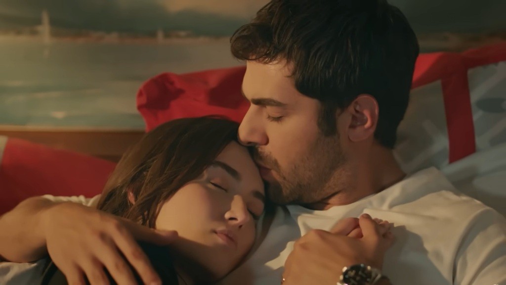 Halil całuje śpiącą żonę w czoło.