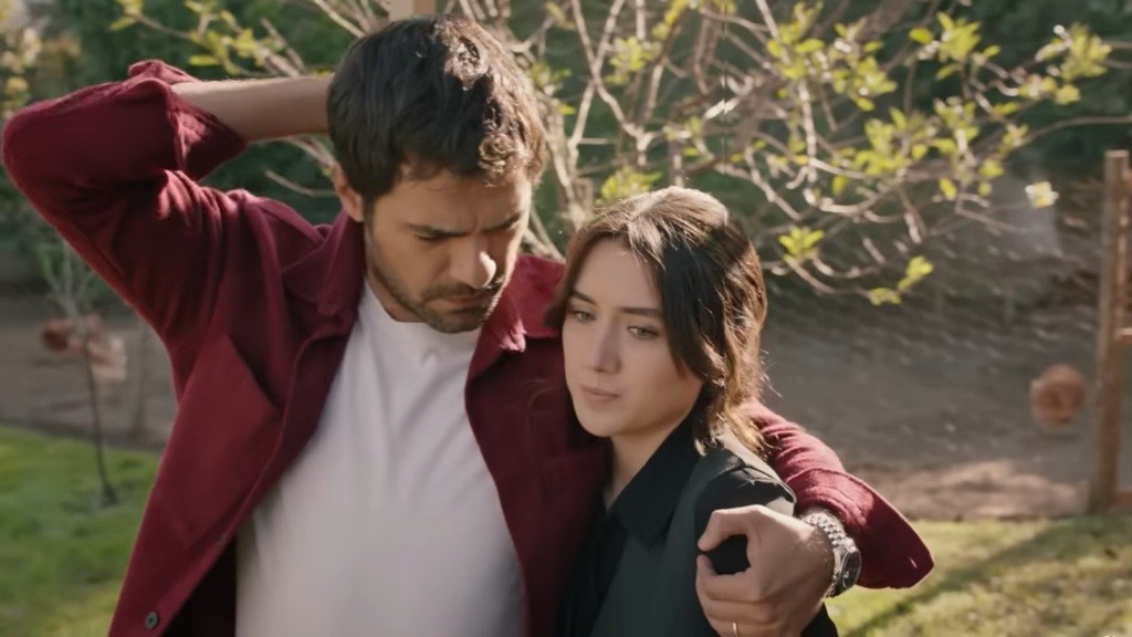 Halil jedną ręką trzyma się za potylicę, a drugą opiera na ramieniu Zeynep.