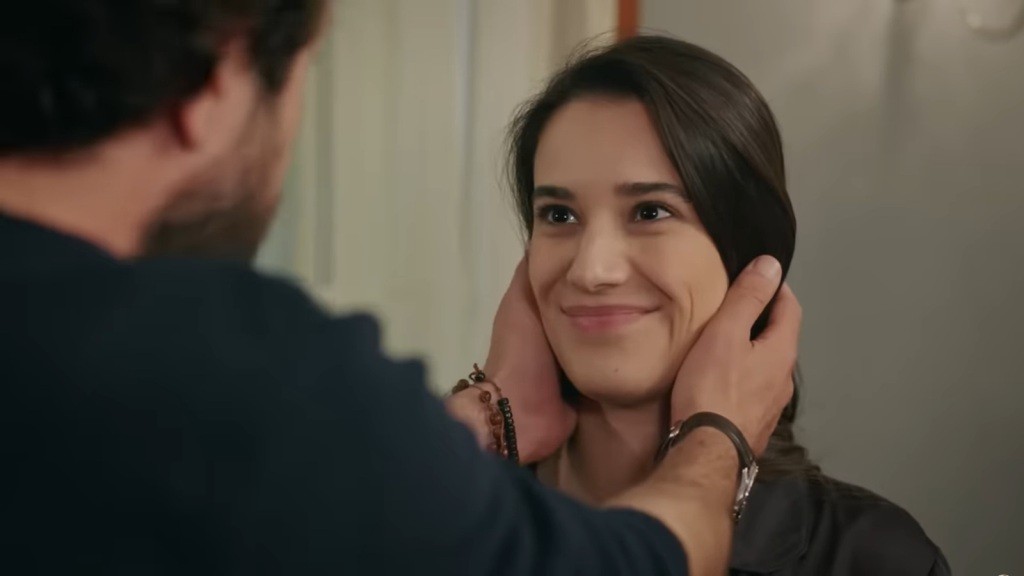 Gulhan uśmiecha się, podczas gdy jej mąż obejmuje dłońmi jej policzki.