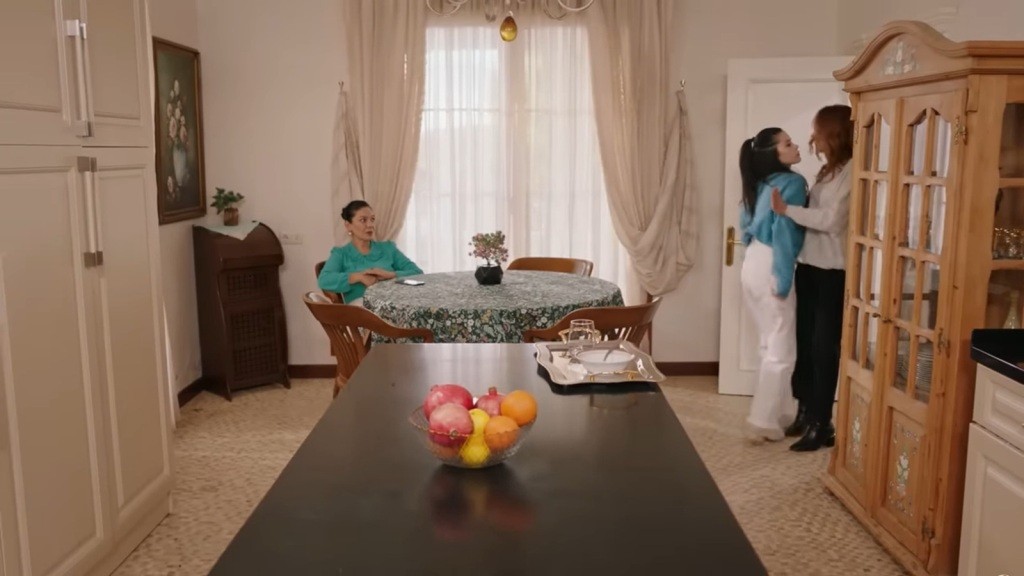 Merve wpada na Songul, wychodząc z kuchni. Przy stoliku siedzi Tulay.