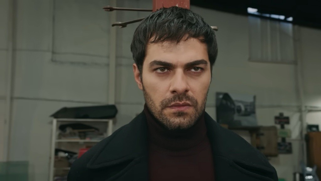 Halil jest przywiązany do metalowego filaru w hali garażowej.