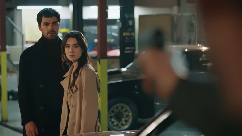 Halil i Zeynep odwracają się w stronę mężczyzny, który mierzy do nich z pistoletu.