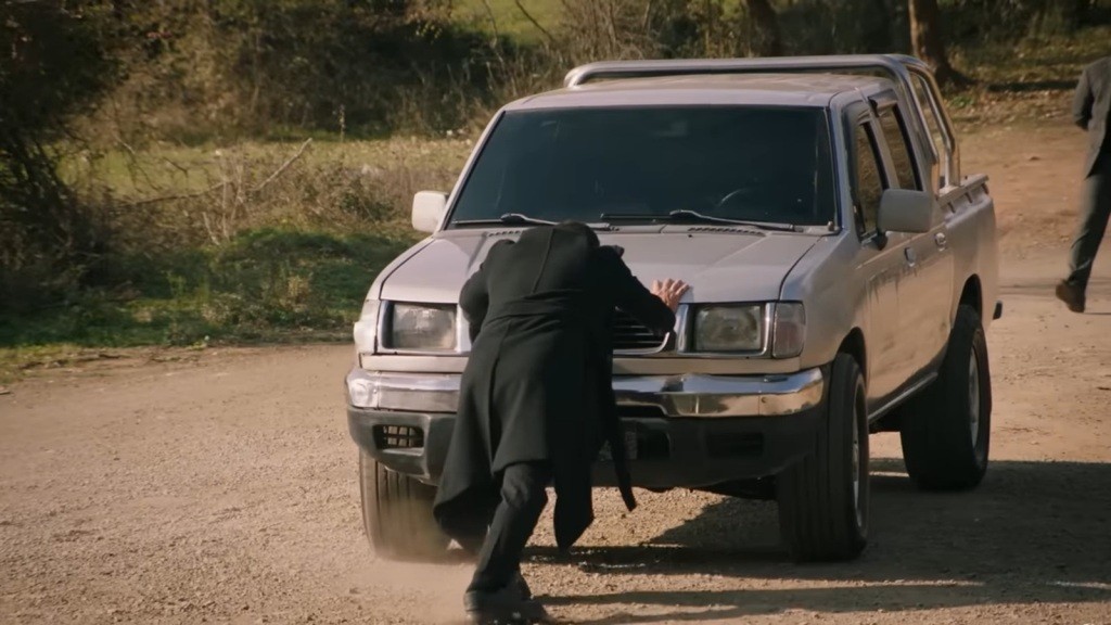 Halil próbuje zatrzymać toczący się samochód.