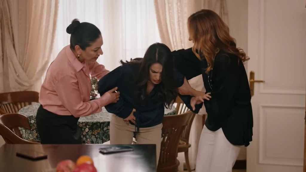 Gulhan chwyta się za brzuch. Jej ciało dręczy intensywny ból skurczów. Tulay i Songul przytrzymując ją mocno, aby nie upadła.