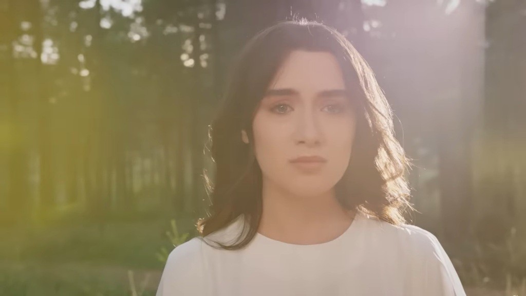 Zbliżenie na zjawę Zeynep, ubraną w białą suknię.