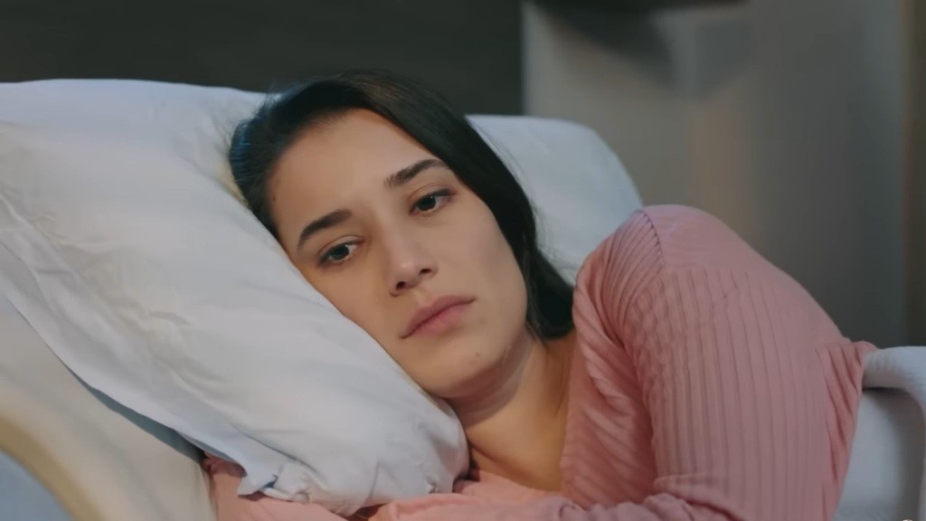 Zbliżenie na twarz Gulhan, wtulającą policzek w szpitalną poduszkę.