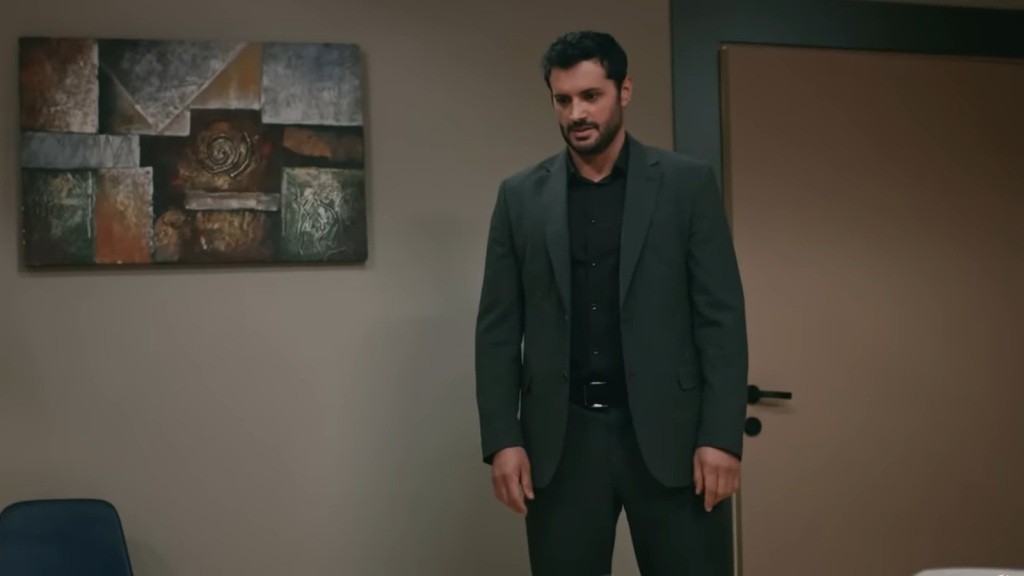 Sadik stoi przed łóżkiem w sali szpitalnej.