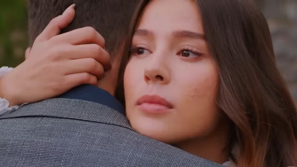 Zbliżenie na twarz Zeynep, przytulającej Egego.