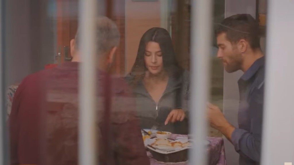 Bulent, Zeynep i Cihan siedzą przy stole i spożywają wspólny posiłek.
