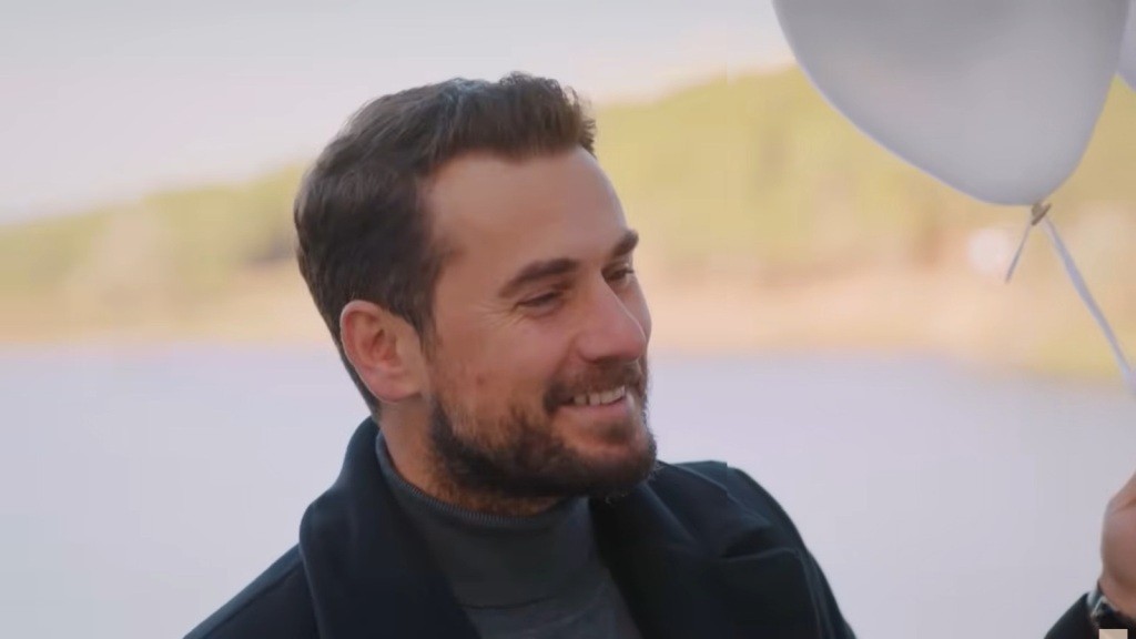 Kuzey śmieje się z dziecięcą radością, trzymając w ręku balon.