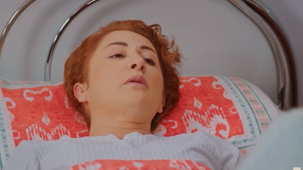 Leżąca na łóżku Hulya otwiera usta, wydobywając z siebie słaby głos.