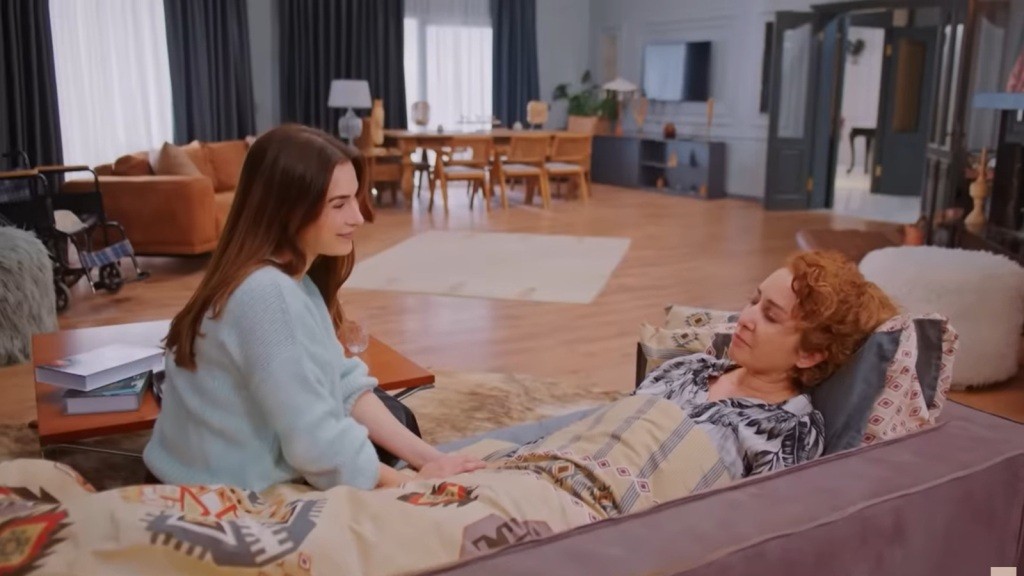 Sila uśmiecha się, siedząc przy leżącej na kanapie Hulyi.