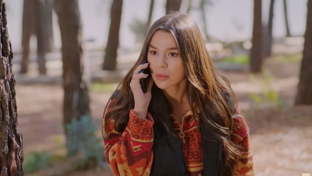 Ege rozmawia przez telefon nad jeziorem.