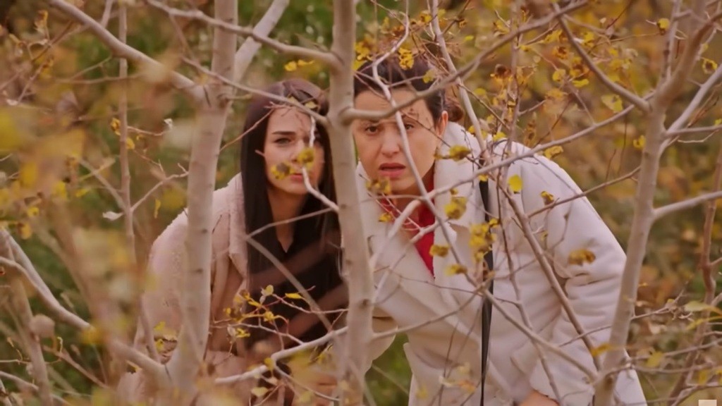 Bahar i Cavidan chowają się za zaroślami.