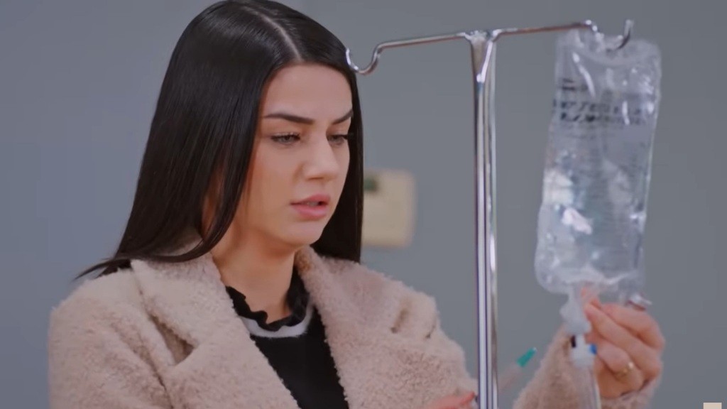 Bahar zbliża strzykawkę do woreczka z kroplówką.