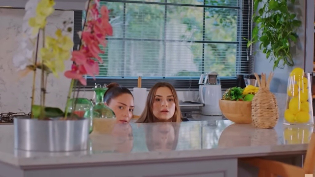 Yildiz i Hulya unoszą głowy ponad blat, chowając się za wyspą kuchenną.