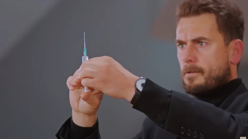 Kuzey trzyma strzykawkę w rękach.