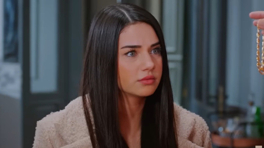 Bahar patrzy na złotą bransoletkę.