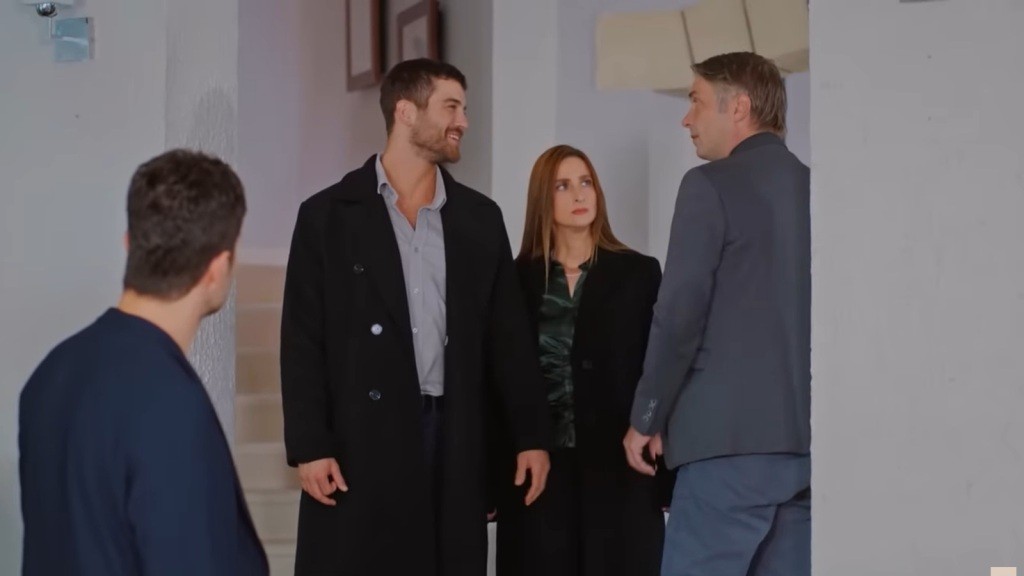 Cihan patrzy na Tahira z kpiącym uśmieszkiem. Obok stoi Ilkay, żona Tahira.