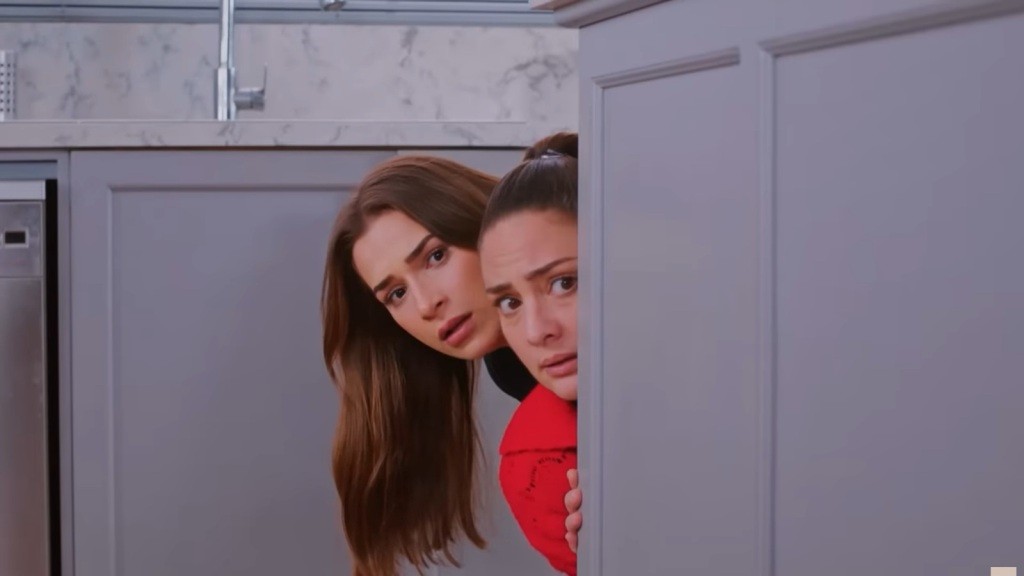 Sila i Yildiz wyglądają zza szafek kuchennych.