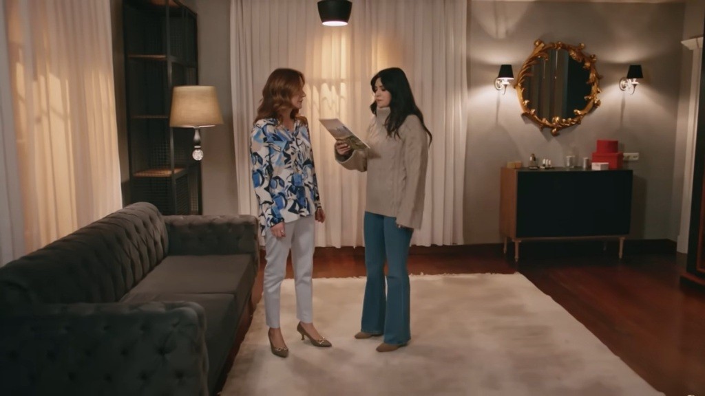 Gozde stoi naprzeciwko Songul w jej pokoju. W ręku trzyma gazetę.