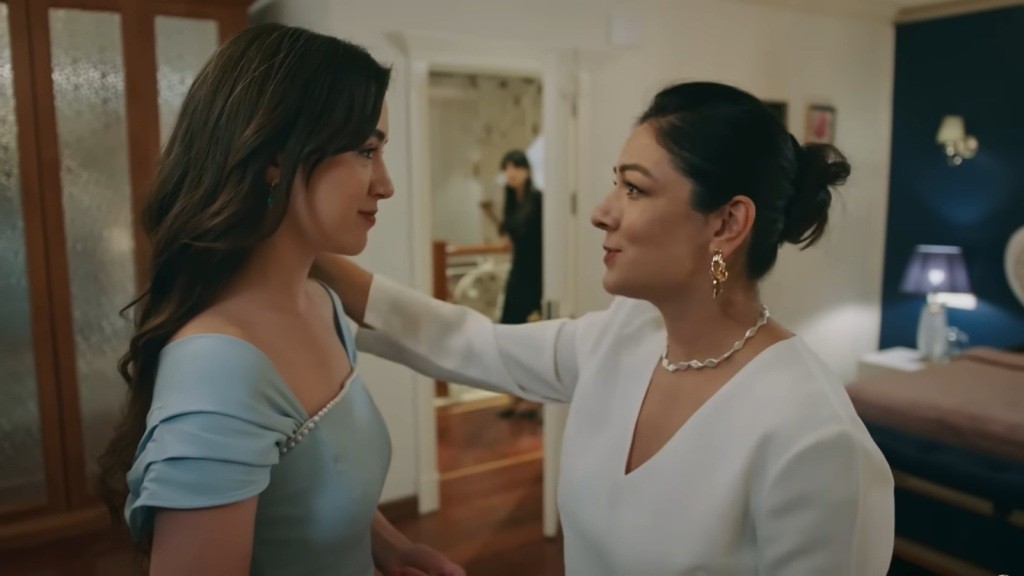 Zeynep ubrana jest w błękitna suknię wieczorową. Matka dotyka jej ramienia.