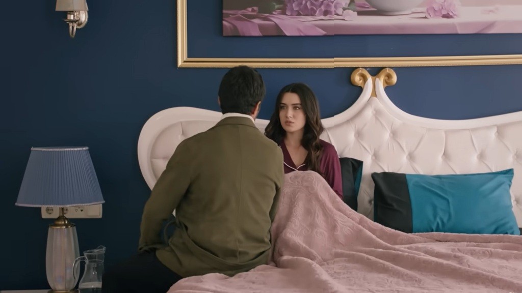 Halil siedzi na skraju łóżka, naprzeciwko Zeynep.