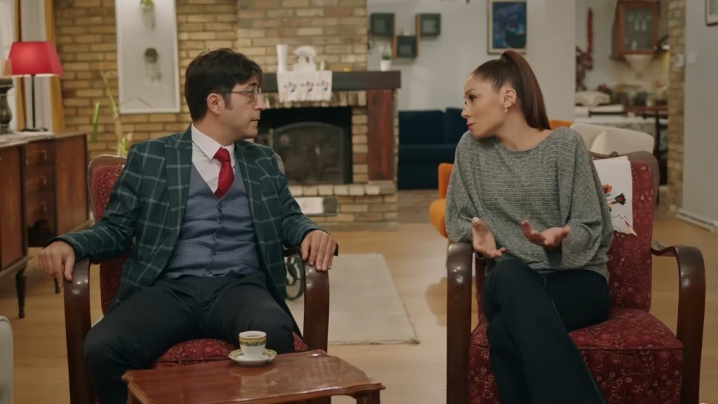 Kumru i Umut siedzą w fotelach obok siebie.