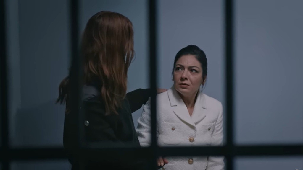 Nowa osadzona kładzie rękę na ramieniu Tulay, stojąc obok niej.