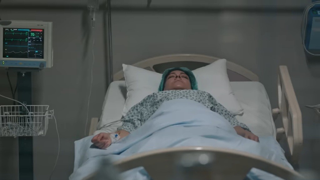 Tulay leży nieprzytomna na szpitalnym łóżku.