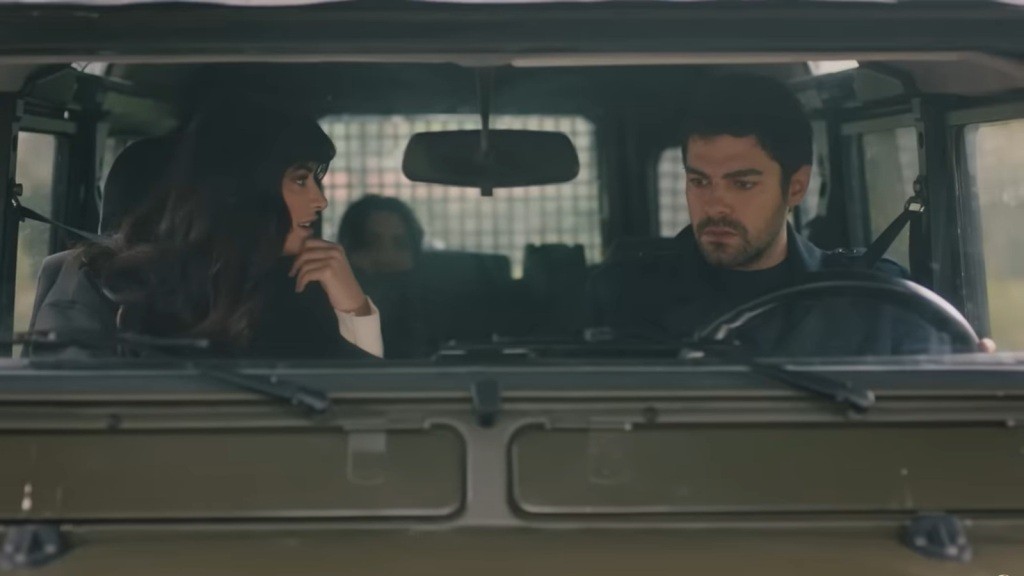 Gozde i Halil siedzą na przednich fotelach samochodu. Zza tylnego rzędu siedzeń dyskretnie wynurza się Zeynep.