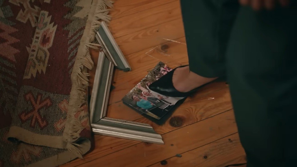 Songul nastaje butem na zdjęciem Aslanlich. Obok fotografii leży rozbita ramka.