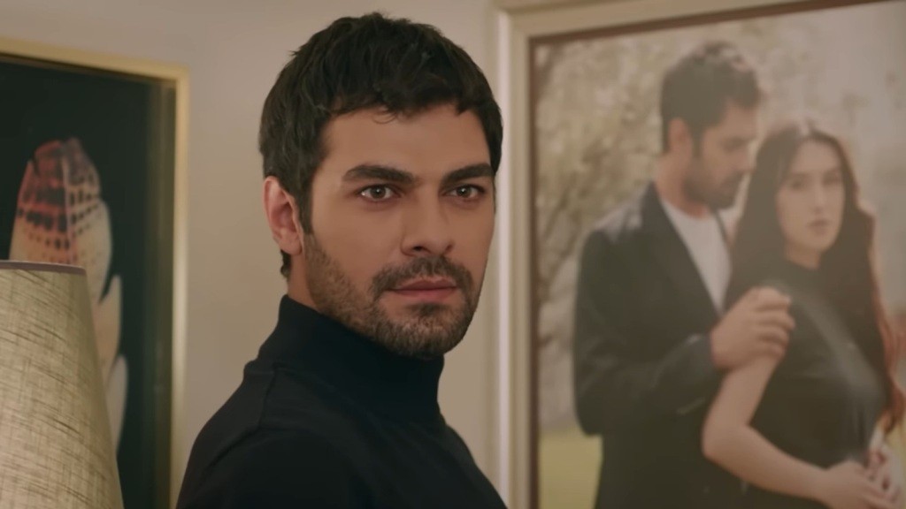 Halil zatrzymuje się przy wiszącym na ścianie zdjęciu, które przedstawia jego i Zeynep.