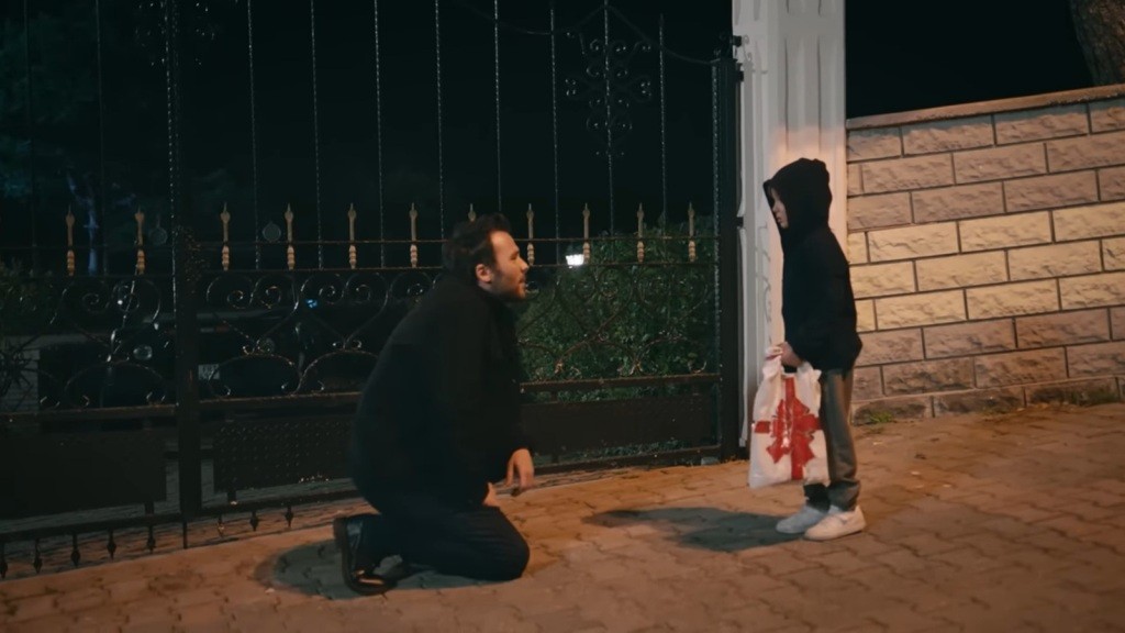 Hakan kuca przed bezdomnym chłopcem.