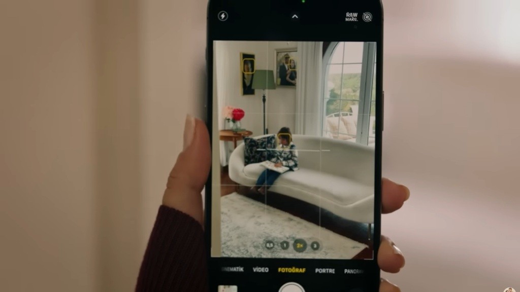 Gozde robi zdjęcie siedzącemu na sofie Ardzie.