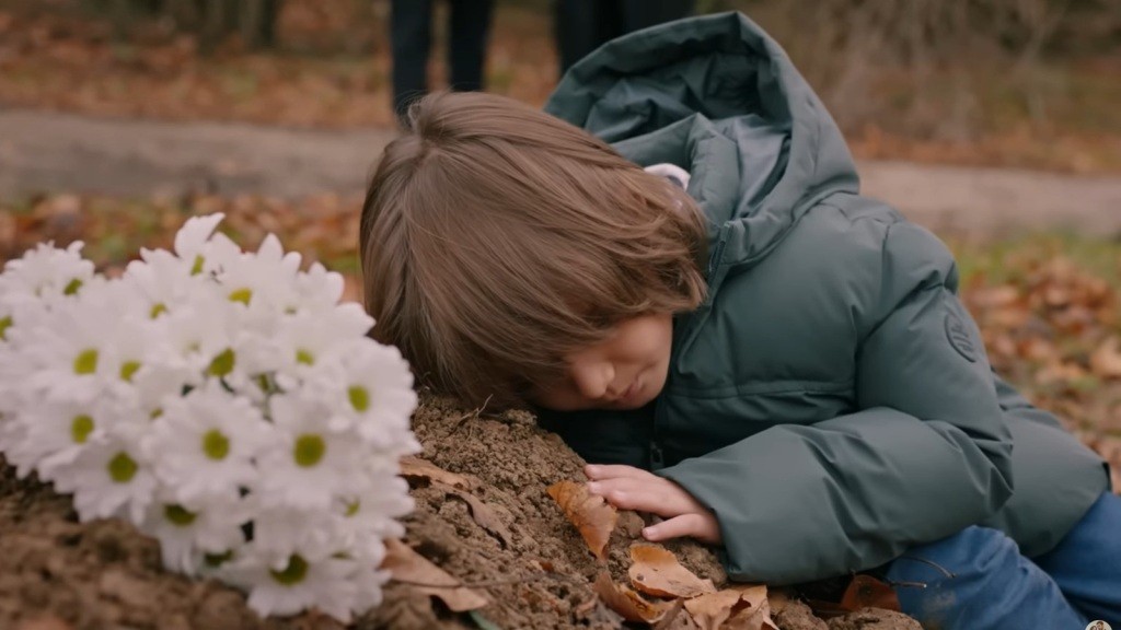 Arda przytula się do grobu mamy.