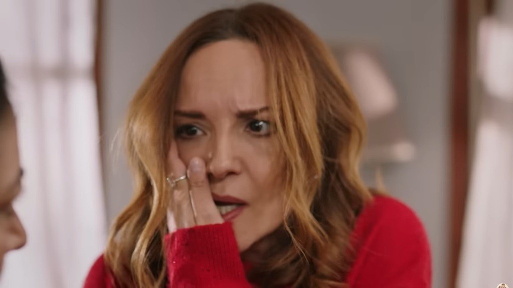 Songul trzyma się za obolały policzek.