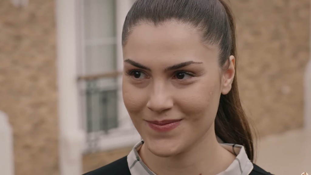 Arzu uśmiecha się przebiegle.