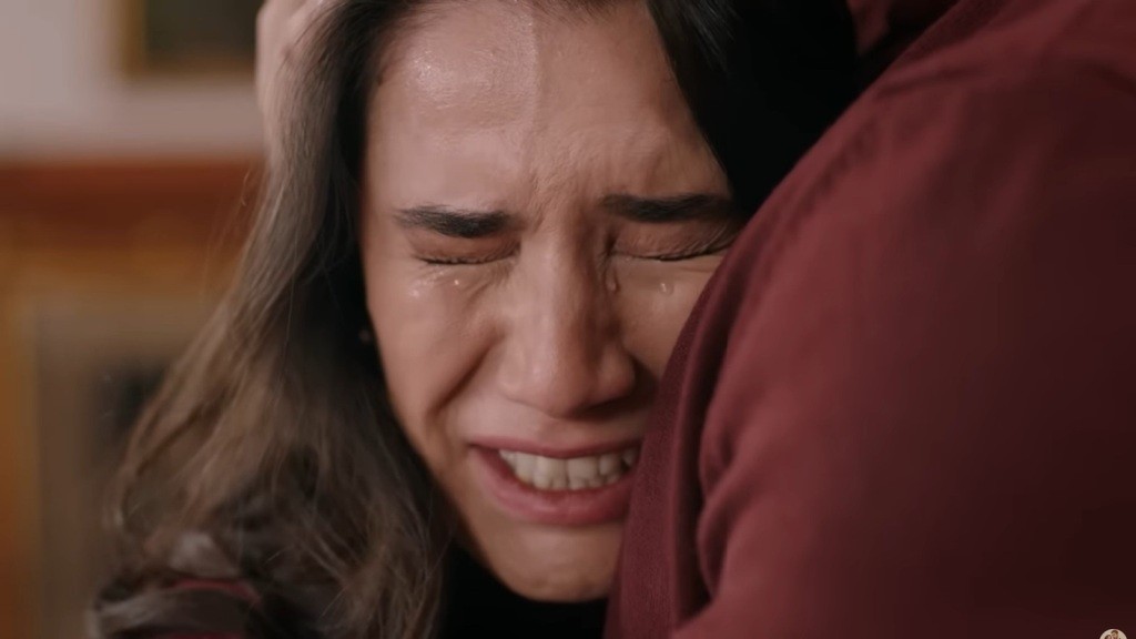 Zapłakana Gulhan wtula policzek w pierś brata.