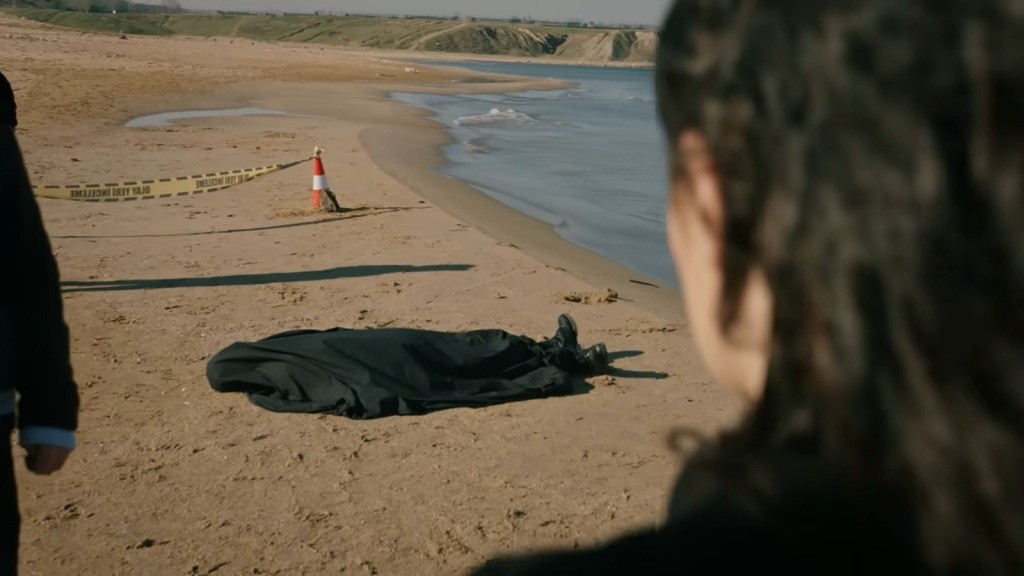 Zeynep patrzy w kierunku ciała przykrytego czarną płachtą.