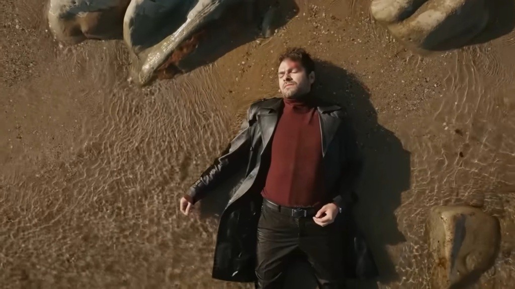 Nieprzytomny Halil leży na brzegu morza.