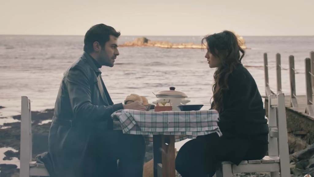 Halil i Zeynep siedzą przy stoliku nad morzem.