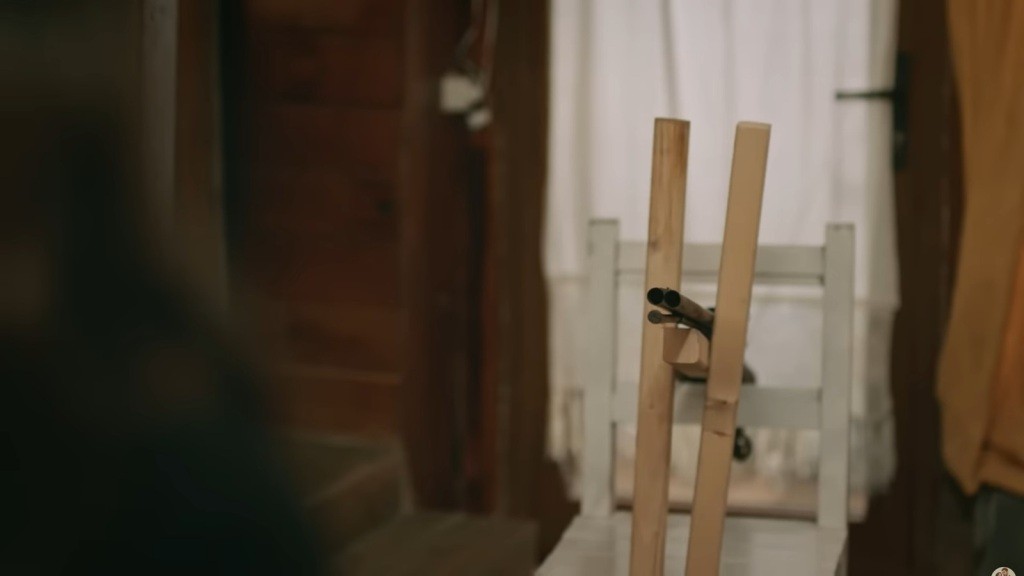 Strzelba przymocowana do krzesła, wymierzona w Zeynep.