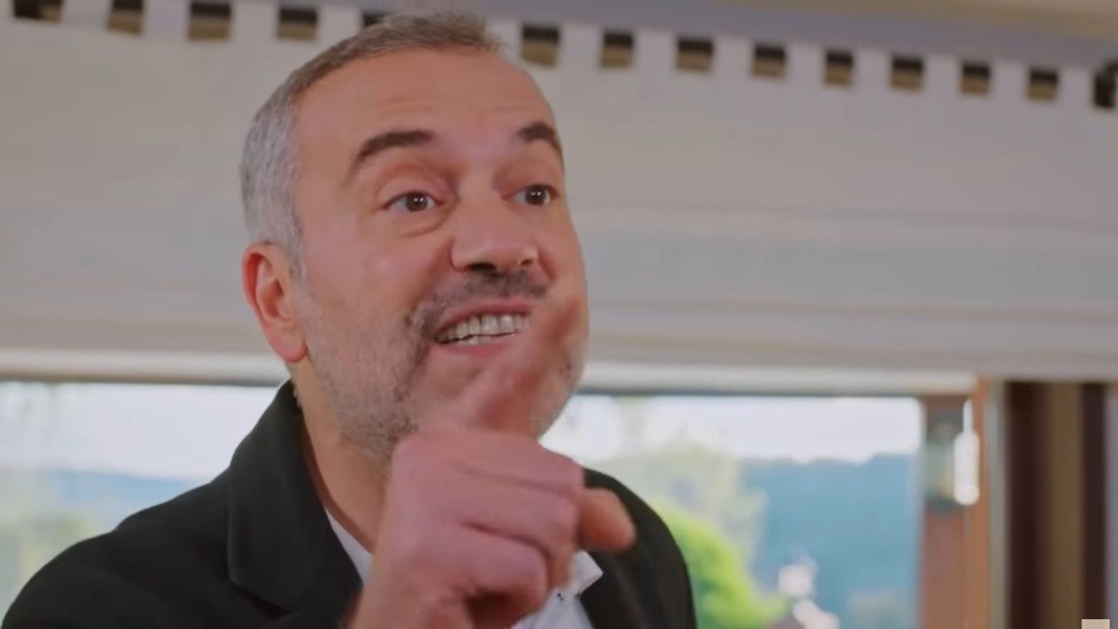 Bulent podnosi palec i krzyczy coś w emocjach.