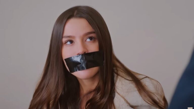 Zbliżenie na twarz porwanej Zeynep. Jej usta są zaklejone czarną taśmą.