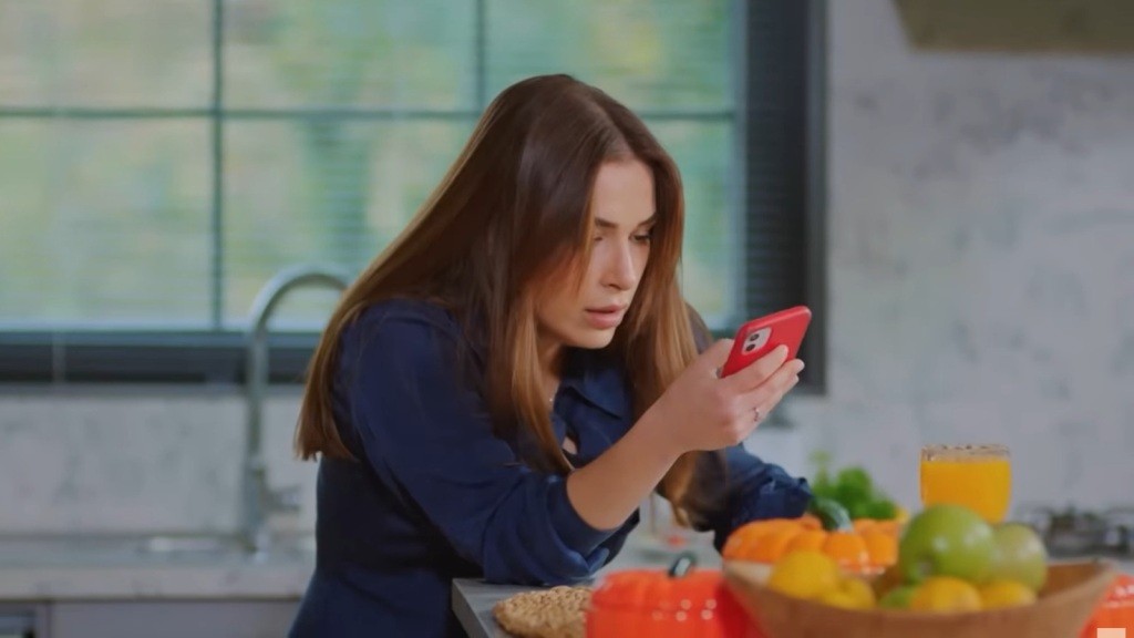 Sila opiera się o krawędź blatu kuchennego, bliska omdlenia. W ręku trzyma telefon i próbuje wezwać pomoc.