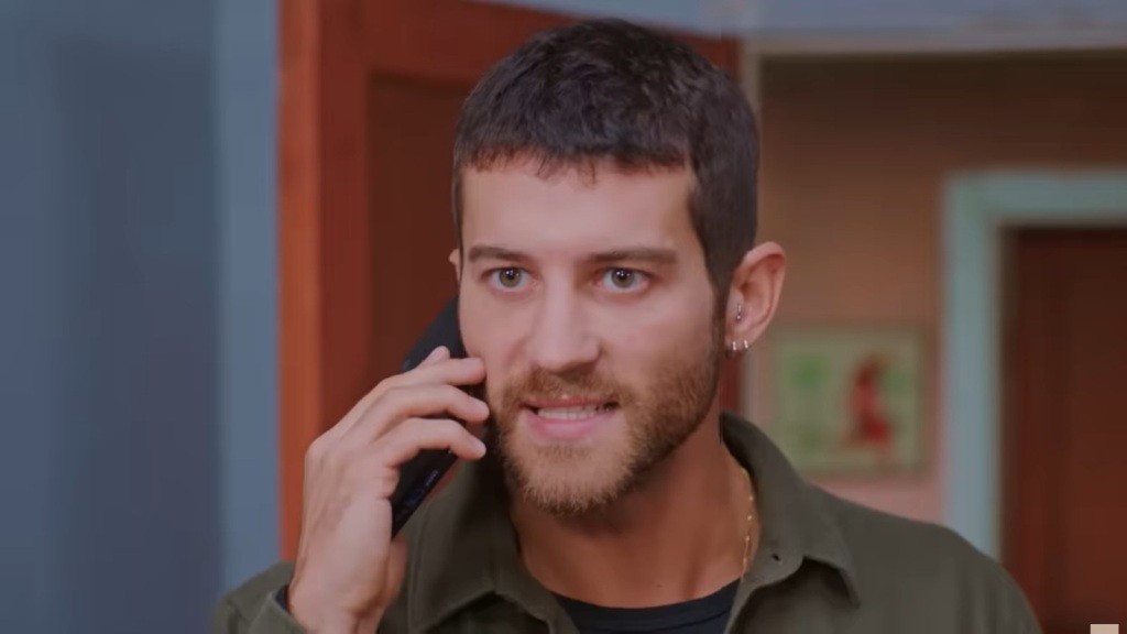 Cihan w napięciu rozmawia przez telefon.