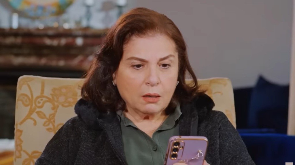 Naciye odczytuje wiadomość SMS od szantażysty.